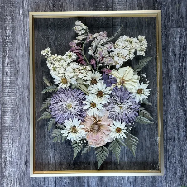 Large pressed flower frame with a full preserved bouquet arranged behind glass