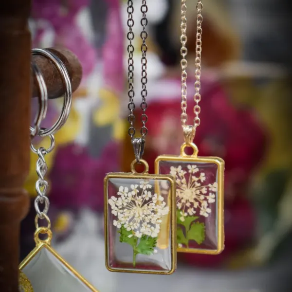 Resin necklace pendant holding a real preserved wedding flower petal