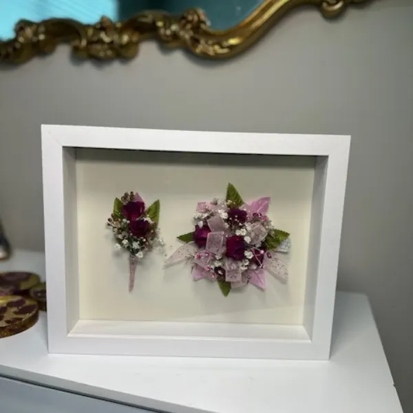 Glass shadow box displaying a dimensional preserved bouquet